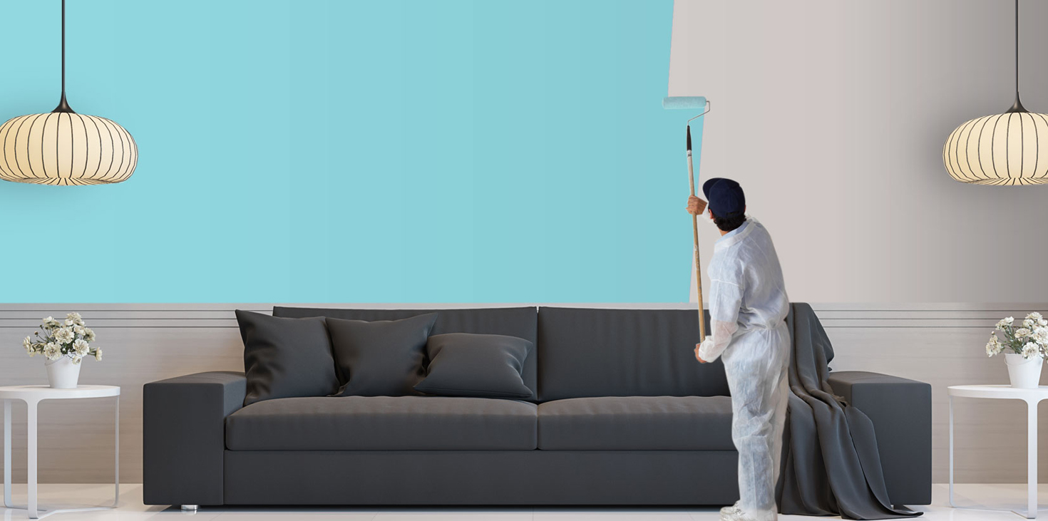 sterling painting services worker painting a living rome from white walls to turquoise.